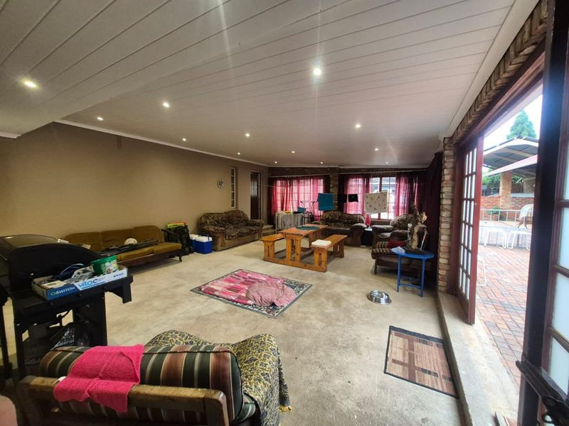 Spacious covered patio area featuring a timber-look ceiling with recessed lighting and direct access to the outdoor garden space through timber-framed glass doors.