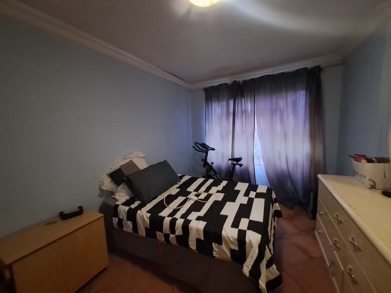 A standard bedroom featuring tiled flooring and decorative cove cornicing, offering a functional space ready for personalization.