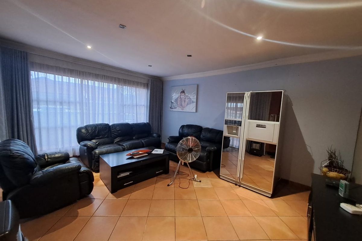 Spacious living room featuring tiled flooring and recessed downlighting, offering a comfortable area for relaxation and entertainment.