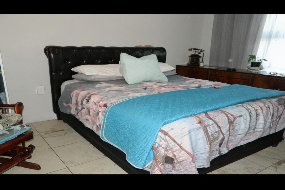 A bedroom featuring tiled flooring, which shows visible signs of cracking and wear, requiring maintenance or replacement.