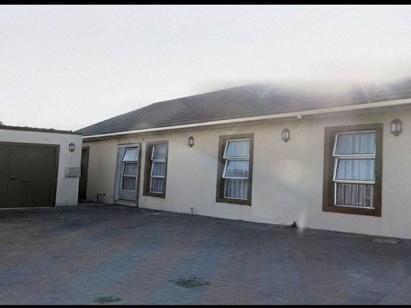 Front exterior view of the property featuring a paved driveway, attached garage, and multiple windows with aluminium frames.