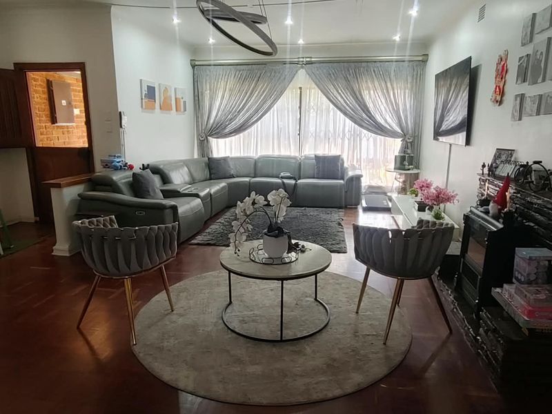 A comfortable living room featuring hardwood flooring, recessed lighting, and a fireplace, with large sliding doors providing access to the exterior.