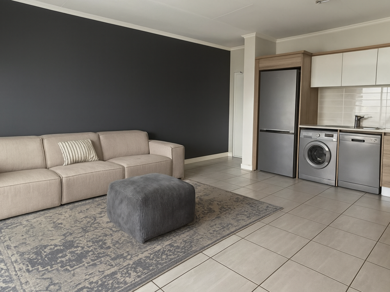 Modern open-plan living area featuring tiled flooring, a dark accent wall, and a compact kitchen equipped with integrated appliances and sleek cabinetry.