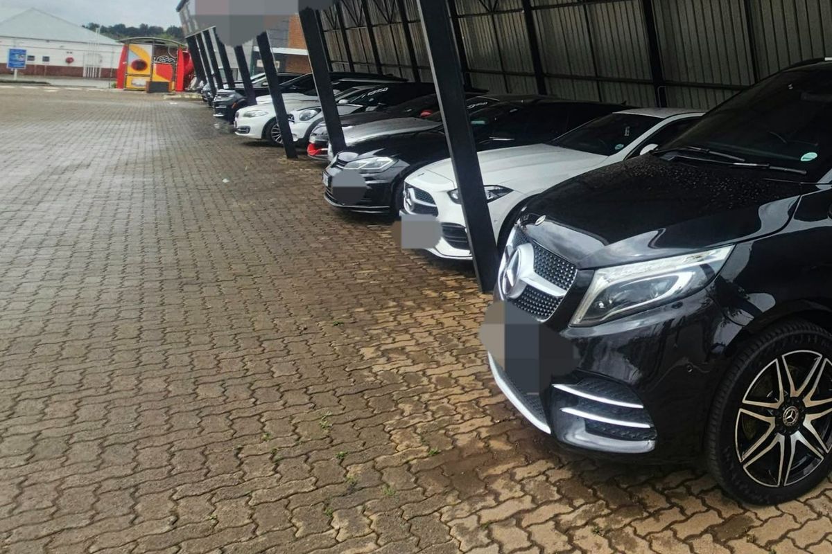 Commercial property featuring a paved outdoor parking area with a covered structure for vehicle protection.