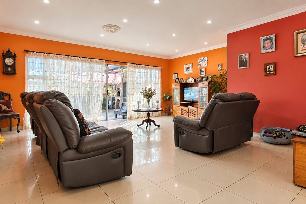 Spacious living room featuring tiled flooring, recessed downlighting, and large sliding glass doors providing access to the outdoor area.