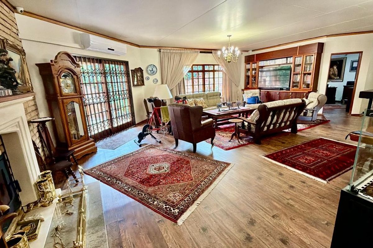 Spacious living room featuring a brick fireplace, built-in cabinetry, laminate flooring, and direct access to the exterior through sliding glass doors.