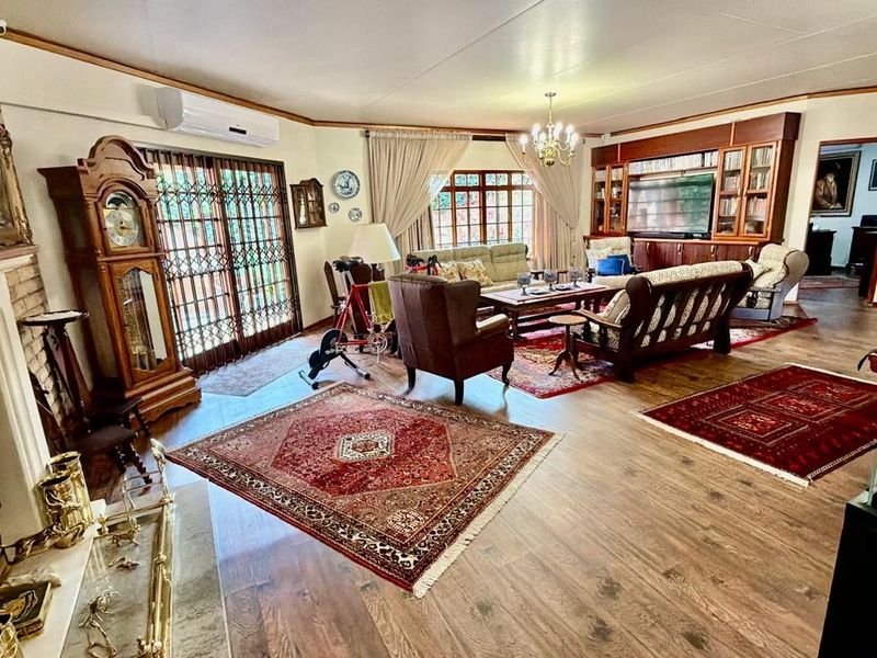 Spacious living room featuring a brick fireplace, built-in cabinetry, laminate flooring, and direct access to the exterior through sliding glass doors.