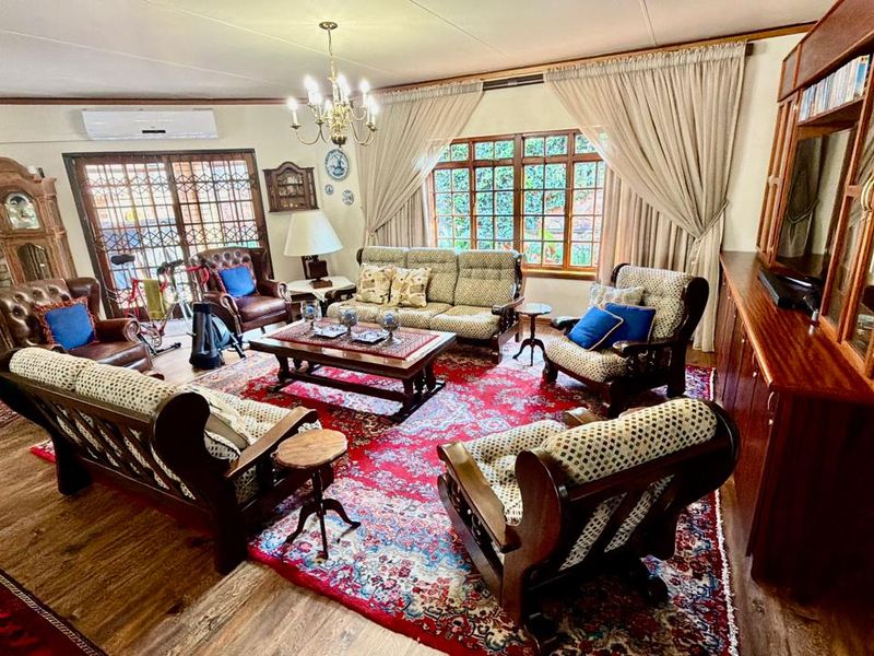 Spacious living room featuring a brick fireplace, split-system air conditioning, and large sliding glass doors providing access to the outdoor area.