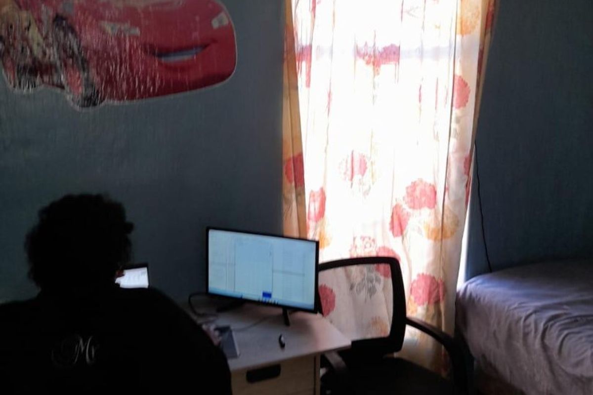 A bedroom featuring tiled flooring and coved ceiling, currently utilized as a workspace.