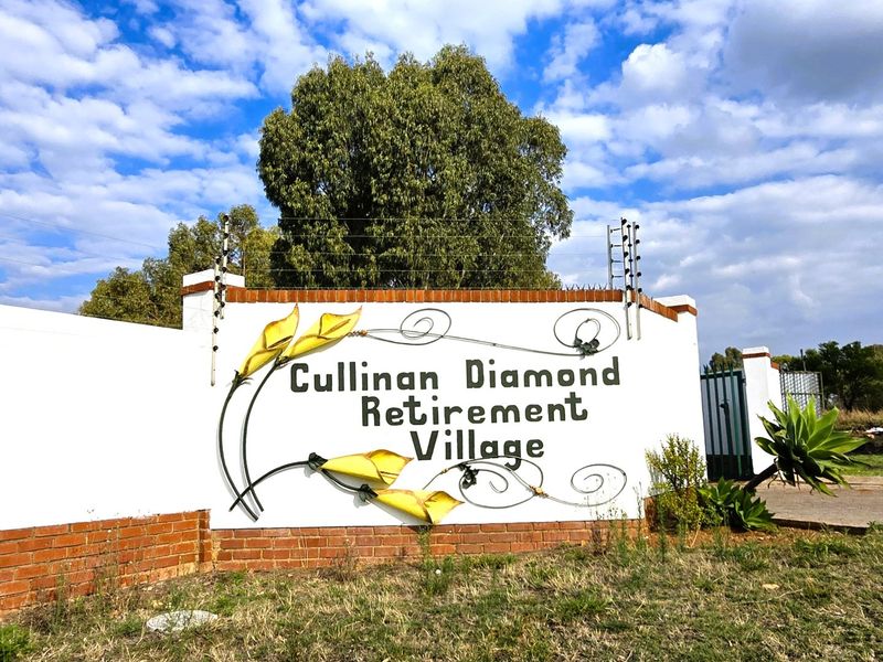 The entrance signage and perimeter wall of Cullinan Diamond Retirement Village, featuring brick detailing and integrated electric security fencing.