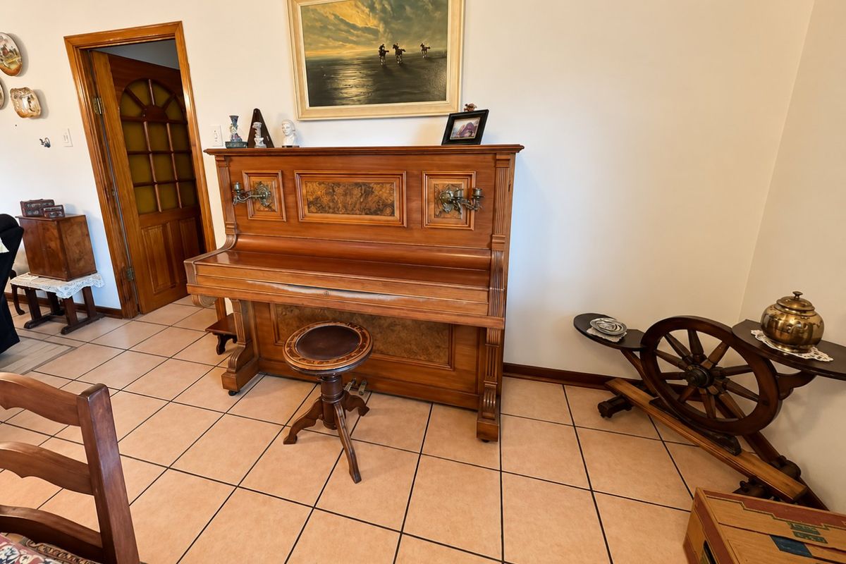 A living area featuring ceramic floor tiles and a traditional wooden door with glass inserts, providing a classic foundation for interior updates.