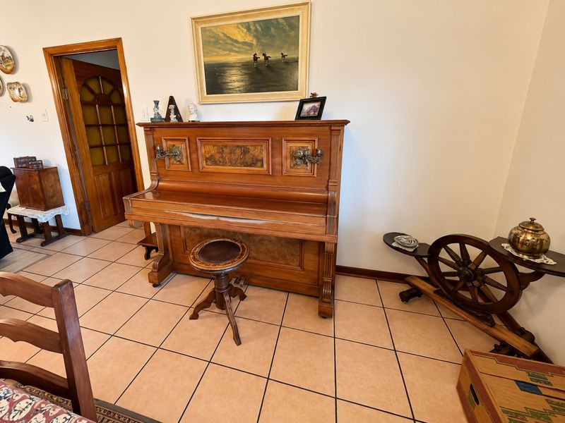 A living area featuring ceramic floor tiles and a traditional wooden door with glass inserts, providing a classic foundation for interior updates.
