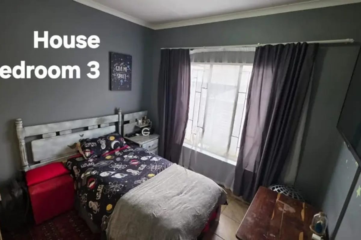 A bedroom featuring dark grey walls, tiled flooring, and a window with fitted curtain rods.
