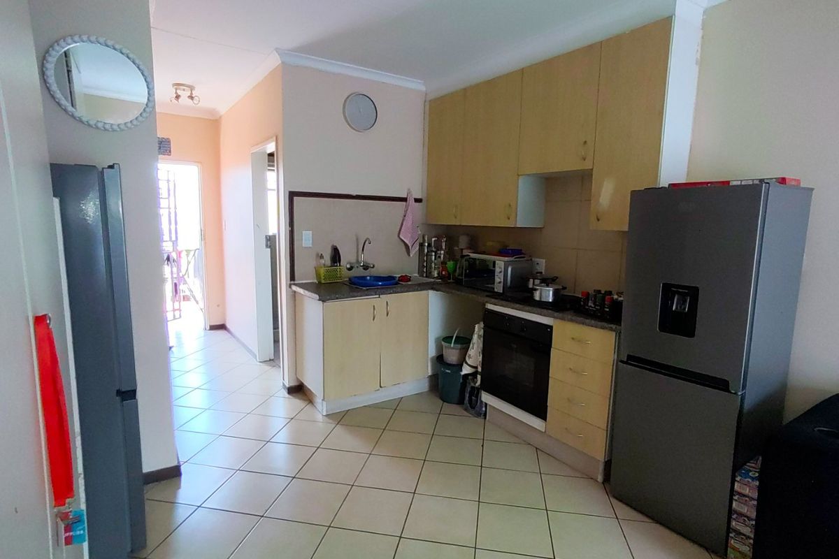 A functional kitchen featuring built-in cabinetry, laminate countertops, a built-in oven, and tiled flooring, offering a practical layout for daily use.