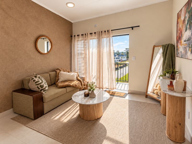 A bright and well-maintained living room featuring textured accent wallpaper, tiled flooring, and a sliding glass door leading to a private balcony.