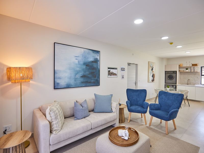 A modern open-plan living area featuring tiled floors, recessed lighting, and a sleek kitchen with built-in cabinetry and integrated appliances.
