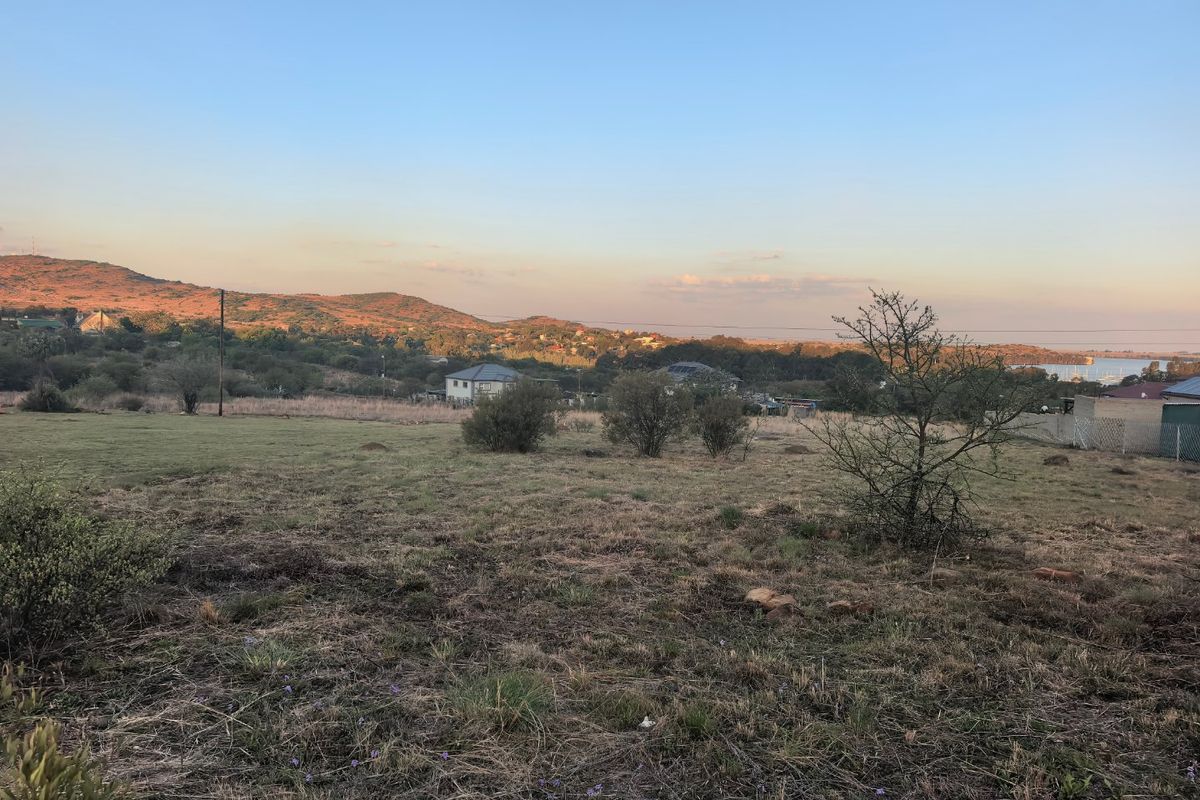 A scenic view of the surrounding landscape, featuring open terrain and distant hills under a clear sky.