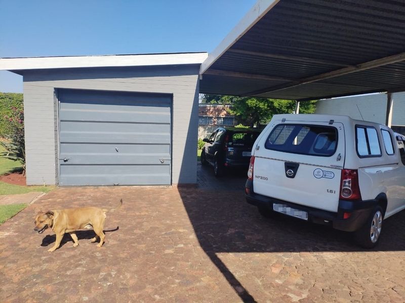 A single garage with an attached carport and paved driveway area.