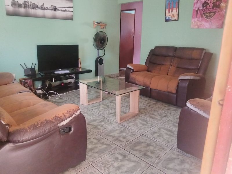 A living room featuring tiled flooring and painted walls, providing a functional space for relaxation.