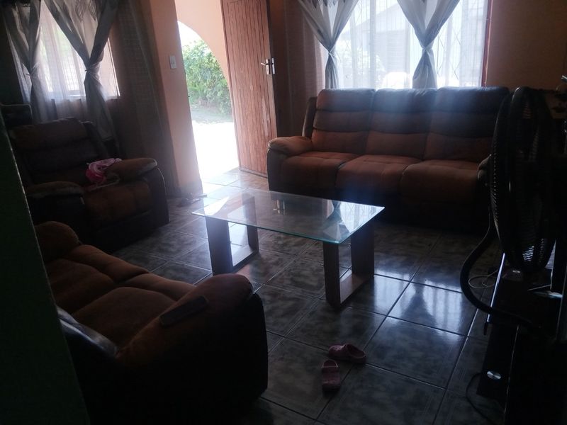 A living room area featuring tiled flooring and an arched doorway leading to the exterior.