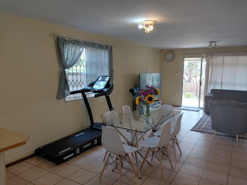 Open plan living and dining area featuring tiled flooring and a sliding glass door providing access to the outdoor space.
