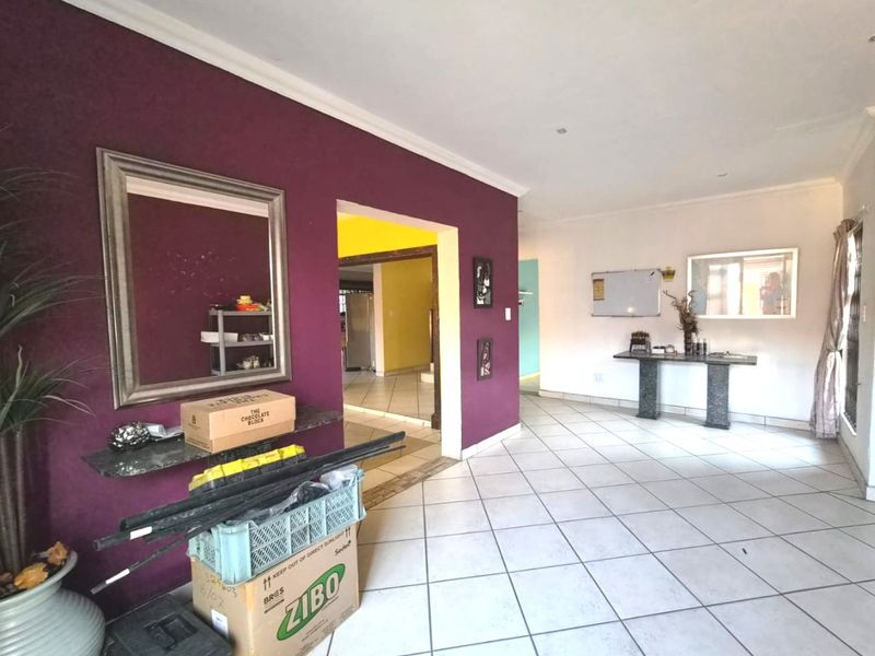 Spacious hallway featuring neutral tiled flooring, recessed downlighting, and coved cornicing, providing a clean and functional transition space between rooms.