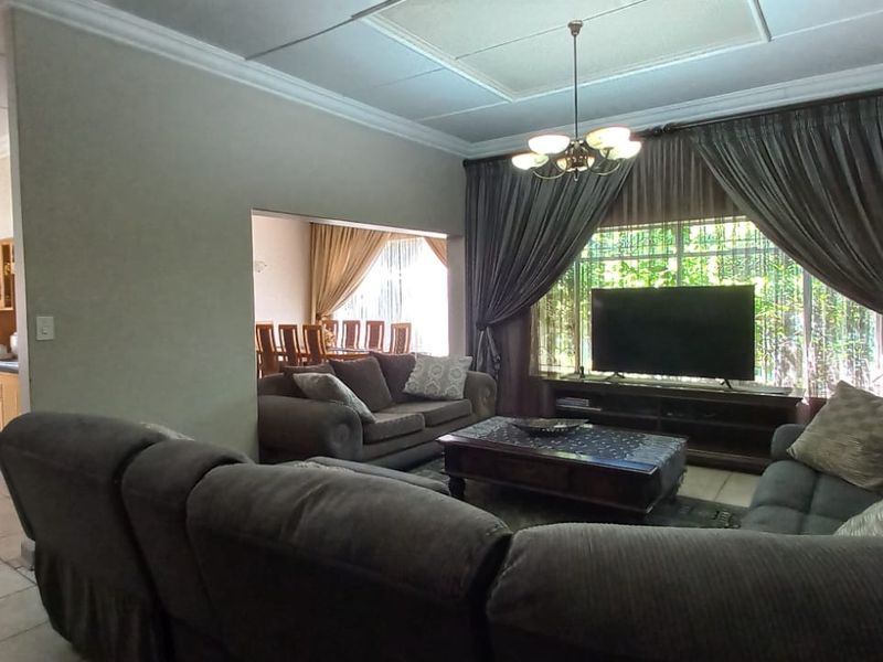 Spacious open-plan living area featuring tiled floors, recessed lighting, and a seamless flow into the adjacent kitchen and dining space.