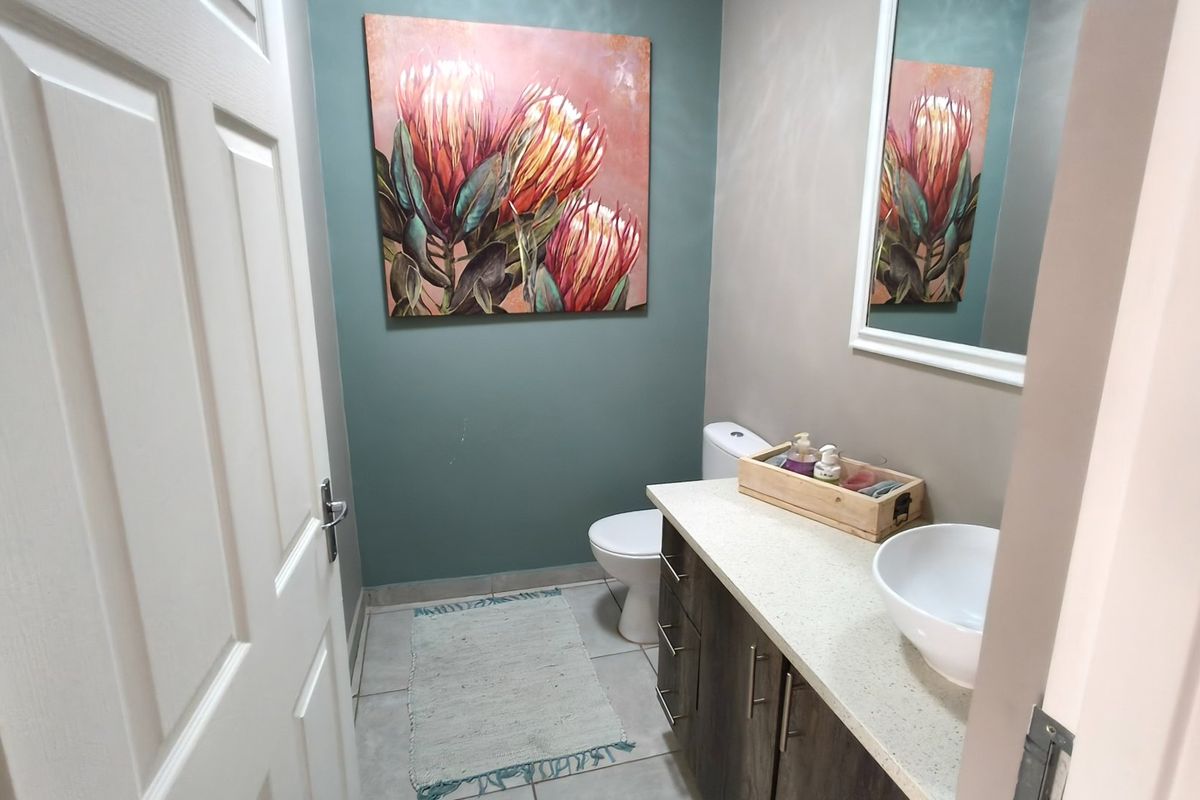 A well-maintained guest bathroom featuring a modern vanity with a stone countertop, vessel sink, and a neutral color palette.