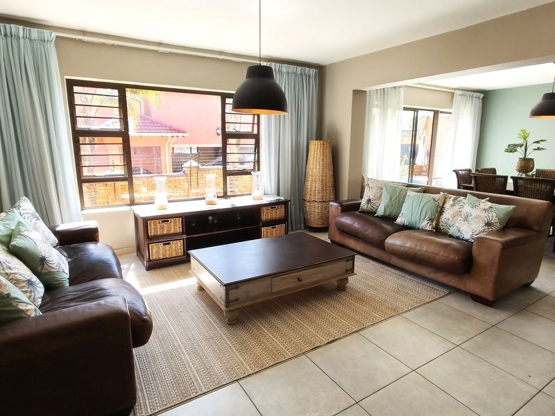 Spacious open-plan living and dining area featuring neutral wall tones, large windows for natural light, and durable tiled flooring throughout.