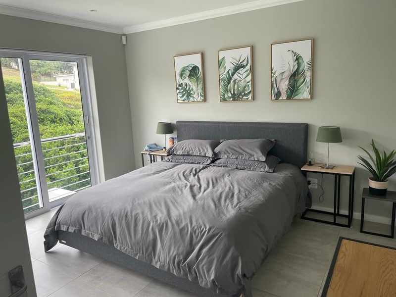 A well-maintained bedroom featuring neutral wall tones, tiled flooring, and a sliding glass door providing access to an outdoor area.