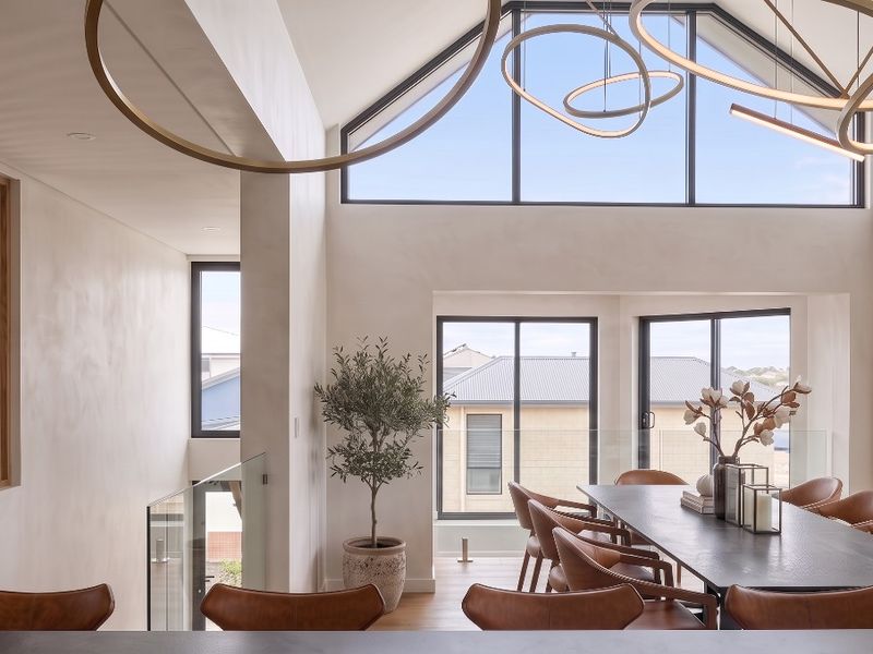 Spacious open-plan living area featuring a dramatic vaulted ceiling, timber slat wall detailing, and expansive windows that provide abundant natural light.