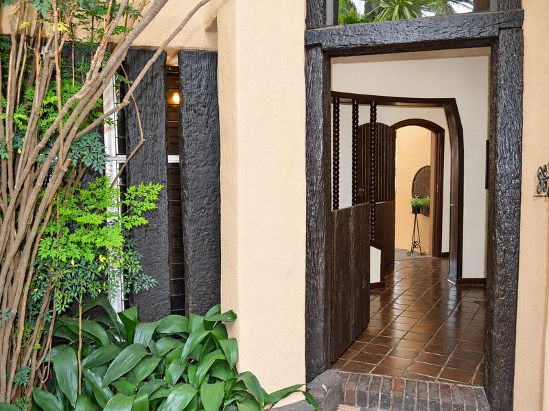 Entrance area featuring a tiled floor, distinctive dark timber door frame, and an arched transition leading into the interior of the home.