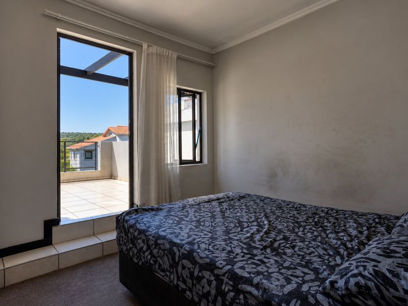 Bedroom featuring carpeted flooring, a raised threshold, and direct access to an outdoor balcony through a sliding glass door.