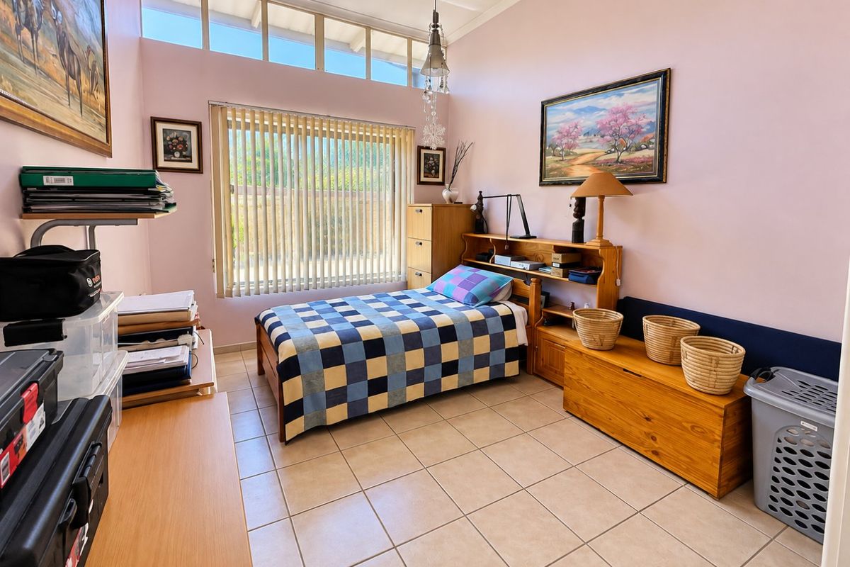 A bedroom featuring tiled flooring, clerestory windows for natural light, and vertical blinds.