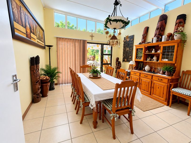 Spacious dining room featuring tiled flooring, high clerestory windows for natural light, and sliding door access to the outdoor area.