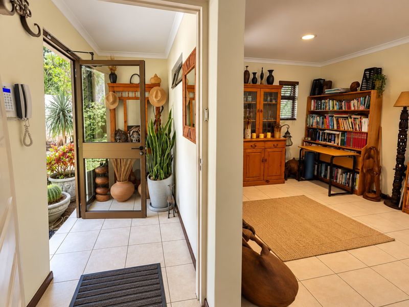 Welcoming entrance hall featuring tiled flooring, an intercom system, and direct access to the outdoor area through a secure glass door.