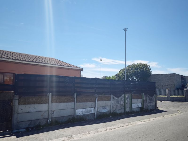 Street view showing the exterior boundary wall and side elevation of the property with a tiled roof.