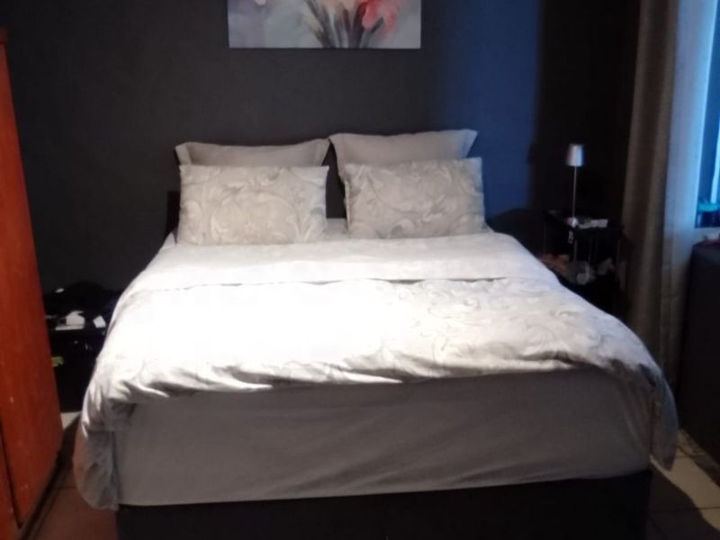 A bedroom featuring tiled flooring and dark painted walls.