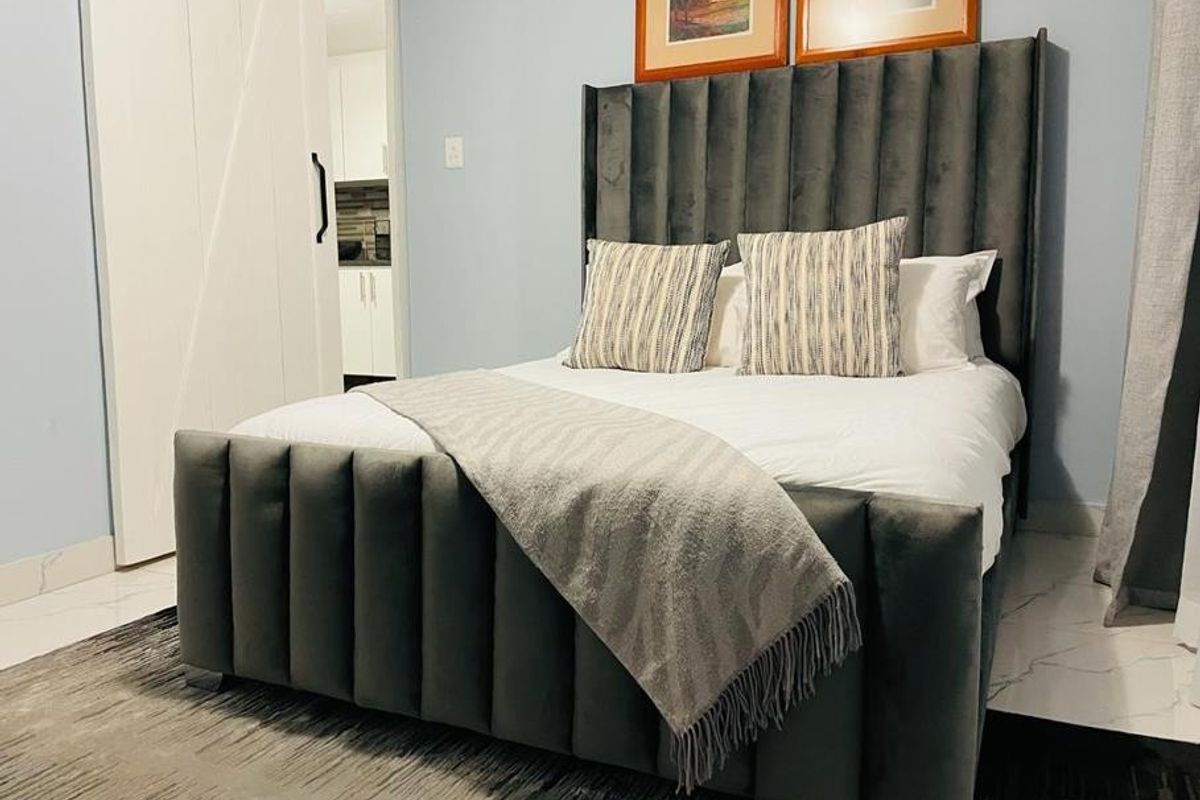 A well-maintained bedroom featuring modern tiled flooring and a stylish sliding barn door leading to an adjacent space.