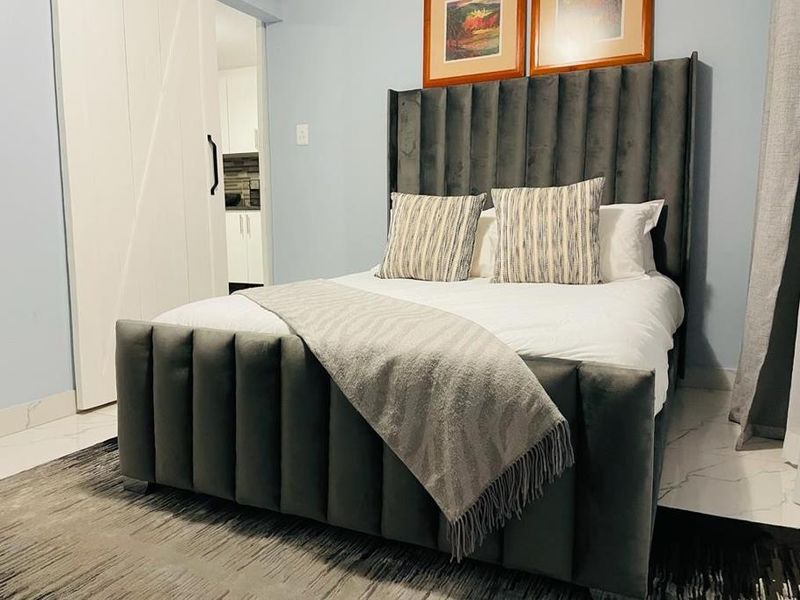 A well-maintained bedroom featuring modern tiled flooring and a stylish sliding barn door leading to an adjacent space.