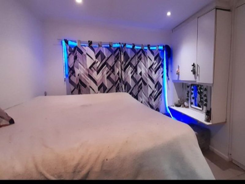 A bedroom featuring built-in cabinetry and a desk area with integrated lighting.