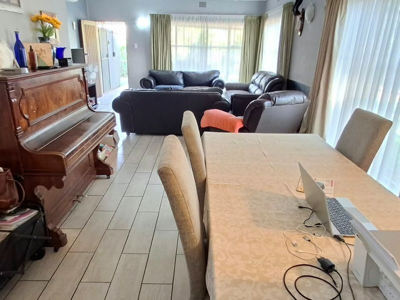 Open-plan living and dining area featuring tiled flooring and large sliding glass doors providing natural light.