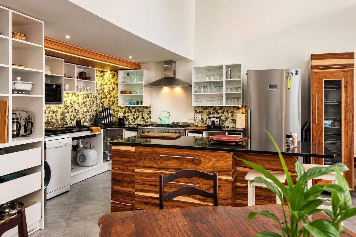 Modern kitchen featuring a central island with stone countertops, custom wood cabinetry, built-in wine fridge, and high-quality stainless steel appliances.