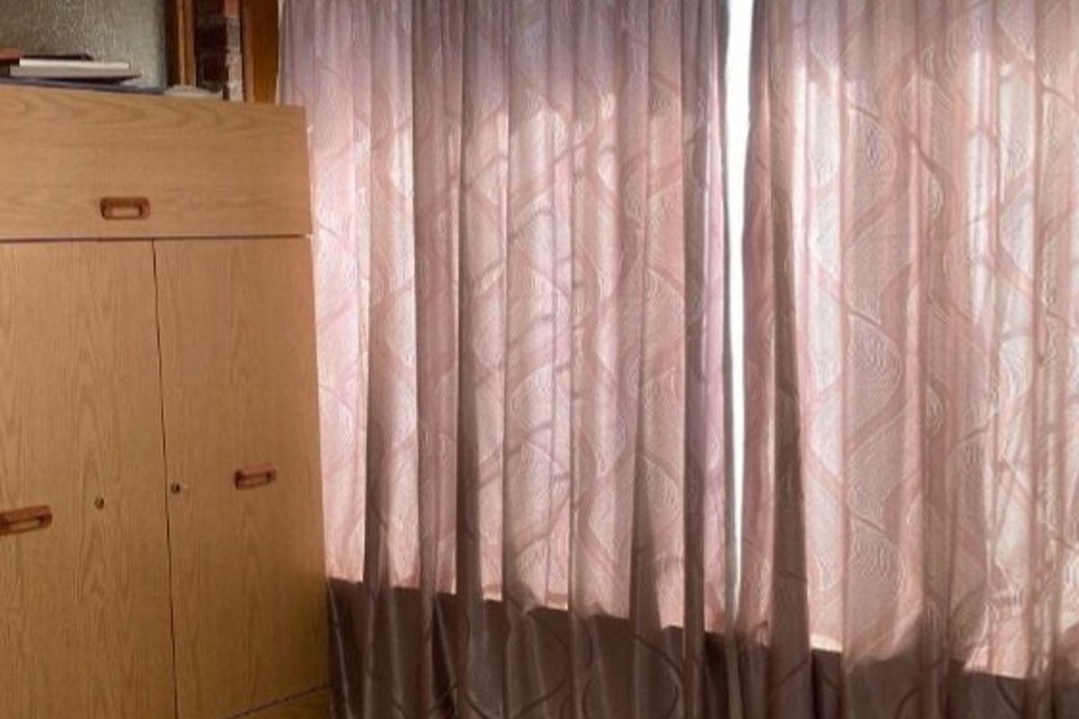 A bedroom featuring a built-in wardrobe and carpeted flooring, requiring cosmetic updates to the ceiling and finishes.