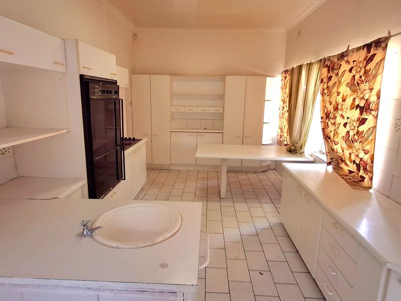Spacious kitchen featuring built-in cabinetry, a double wall oven, and tiled flooring, offering a functional layout ready for modern updates and renovation.