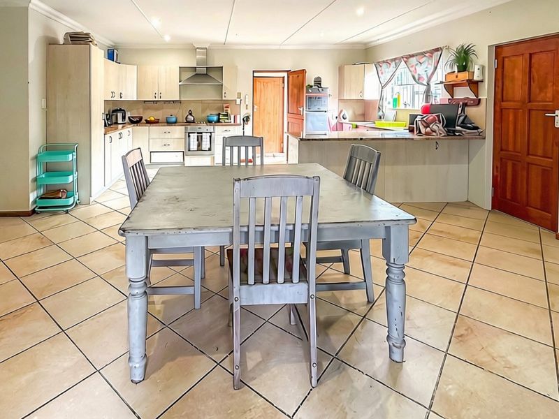Spacious open-plan kitchen and dining area featuring tiled flooring, built-in cabinetry, and a functional kitchen island layout.