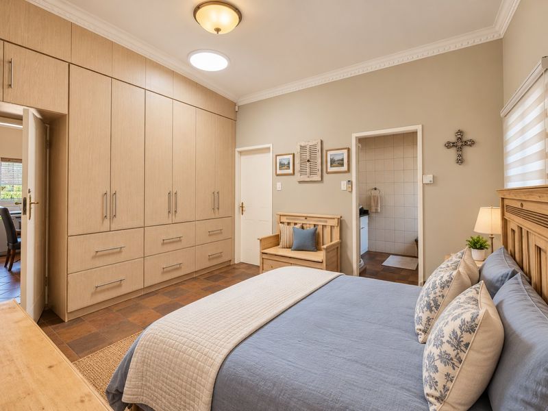 Spacious bedroom featuring extensive built-in cabinetry, tiled flooring, crown molding, and an en-suite bathroom access.