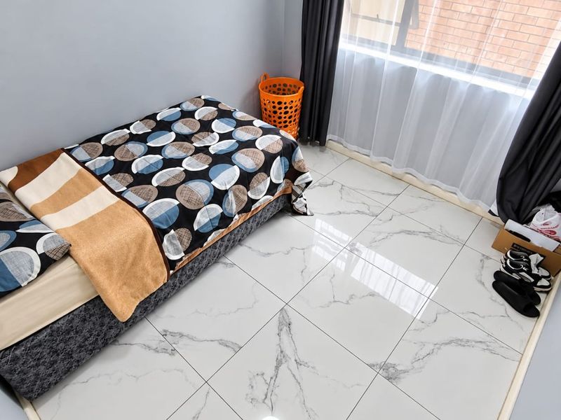 A well-maintained bedroom featuring modern marble-effect floor tiles and large windows with installed curtain tracks.