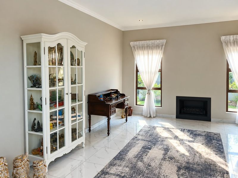 A bright living room featuring polished tiled flooring, a modern built-in fireplace, and large windows with natural light.
