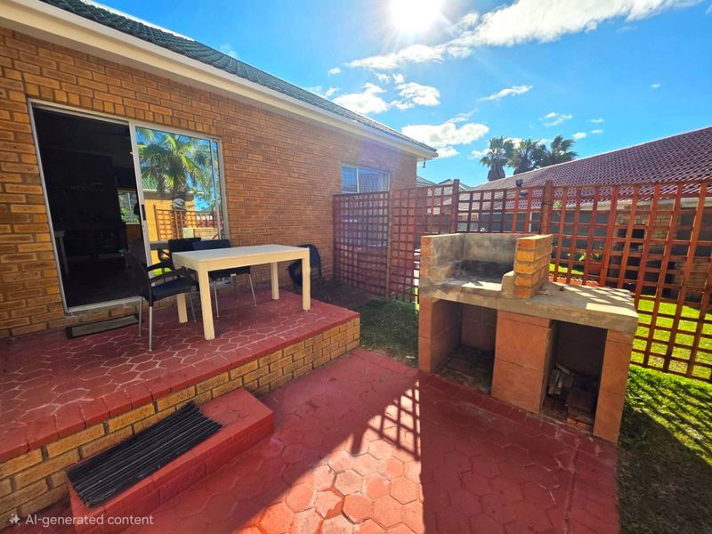 Outdoor patio area featuring a built-in brick braai, paved flooring, and direct access to the interior through a sliding glass door.